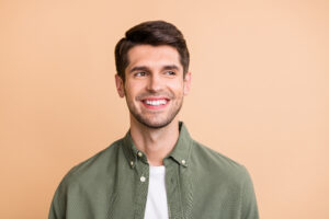 Charming young man smiling on orange background
