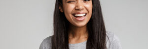 happy smiling young african woman with long dark hair wearing casual clothes standing isolated over gray background