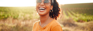 Happy, farm and black woman on holiday in the countryside of Colombia for adventure, peace and calm in summer. Face portrait of African girl with smile for travel vacation in agriculture and nature.