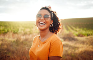 Happy, farm and black woman on holiday in the countryside of Colombia for adventure, peace and calm in summer. Face portrait of African girl with smile for travel vacation in agriculture and nature.